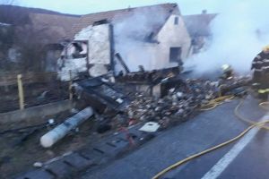 FOTO. Un TIR încărcat cu ciocolată a ars după ce a lovit un stâlp, o ţeavă de gaz, apoi s-a oprit în curtea unei gospodării. Localnicii din sat, fără curent, iar focul s-a extins la acoperiş