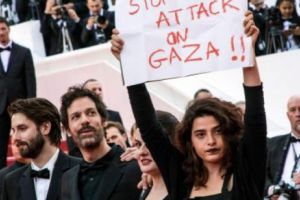Conflictul din Orientul Mijlociu a ajuns la Cannes: o actriţă a păşit pe covorul roşu cu un afiş de susţinere pentru palestinieni