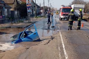 Imagini şocante în Budapesta: Maşină „înghiţită” într-o groapă apărută din senin într-o şosea (FOTO)