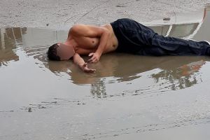 FOTO. Bărbat surprins dormind pe asfalt, pe o stradă inundată!