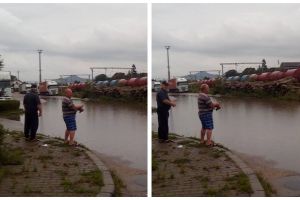 FOTO, VIDEO ȘTIREA TA: „Protest” inedit la Aiud. Un bărbat a ieşit cu undiţa în faţa gării, la „pescăria” formată după ploaie