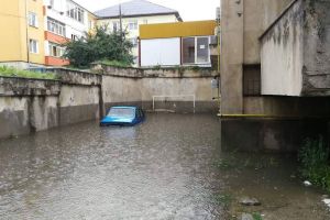 FOTO. Inundaţii la Cugir, după o ploaie torenţială. O maşină, aproape acoperită de ape