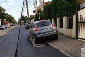 Vai de capul nostru! Politia n-a reusit sa afle a cui e masina, asa ca muncitorii au asfaltat pe langa... In Ploiesti, pe strada Bobalna