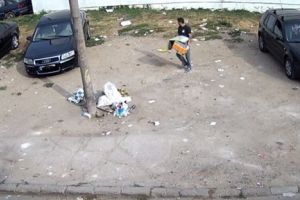 Tanar filmat de camera video cum arunca gunoi din masina, pe o strada din Timisoara