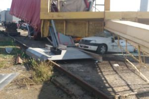 VIDEO VIRAL. O macara se prăbuşeşte peste o maşină, în curtea unei fabrici