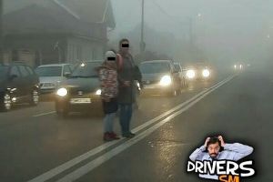 FOTO. Părinte inconştient. Slalom printre maşini cu copilul de mână, pe o ceaţă densă