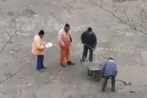VIDEO Groapă plină cu apă, golită cu lopeţile de mai mulţi muncitori