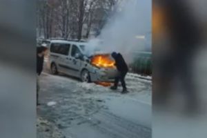 Maşină în flăcări în plină stradă. Focul, stins cu zăpadă de trecători