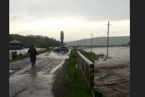 FOTO Drum judeţean inundat! Două persoane au rămas blocate într-un autoturism