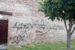 FOTO. Minor “artist” din comuna Meteş, prins şi amendat cu 1.200 de lei de Poliţia Locală. A scris cu spray negru mesaje pe pereţii din şanţurile Cetăţii Alba Carolina