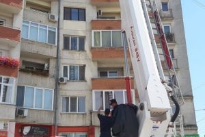 FOTO Pericol public! Tencuiala de pe un bloc, ameninţare pentru cetăţeni. Poliţiaştii locali şi pompierii au interveni