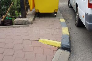 Trotuar cu rampă de acces pentru persoanele cu probleme locomotorii, blocat cu pubele de gunoi