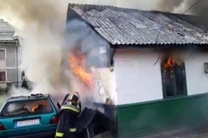 O casă şi maşina parcată lângă aceasta, cuprinse de un incendiu