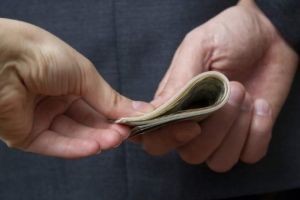 Secretara unei şcoli prinsă în flagrant când lua mită. Ce urma să facă