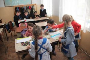 Elevi de vârste diferite învaţă în aceeaşi sală, cu aceeaşi învăţătoare. ...