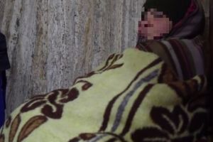 Femeie ţinută în frig de propriul fiu, în judeţ. Doarme pe jos într-o clădire aflată în stare deplorabilă