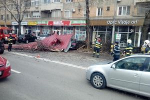 Vântul face ravagii: O parte din acoperişul unui bloc din Oradea s-a prăbuşit peste şosea şi maşinile parcate (FOTO)