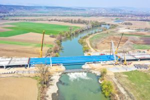 VIDEO SPECTACULOS| Pe autostrada Sebeş-Turda, lotul 2, hărnicie în timpul crizei COVID. La podul peste râul Mureş de la Rădeşti, ”toate grinzile sus”