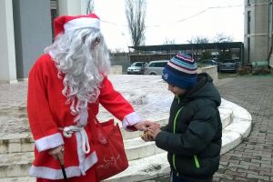 Un Moş Crăciun care împarte bomboane copiilor pe stradă